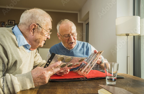Two senior friends with coin album