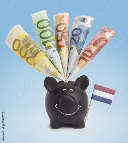 Various european banknotes in a happy piggybank of Netherlands.( photo