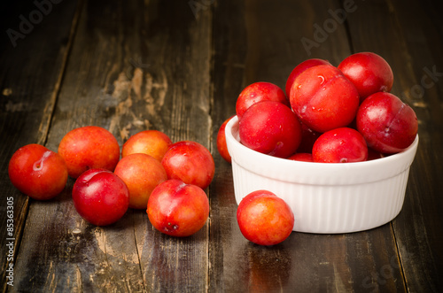 Fresh plum (Julee) on wooden background photo