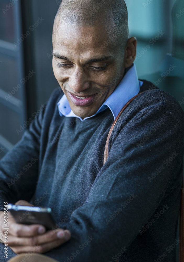 Smiling man outdoors looking on smartphone Smiling man outdoors looking on smartphone
