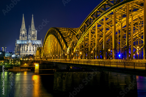 Germany, Cologne, illuminated Cologne Cathedral and Hohenzollern bridge at night #85364706
