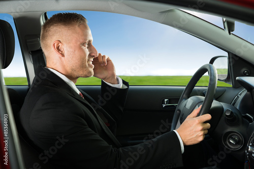 Man Using Cellphone While Driving © Andrey Popov