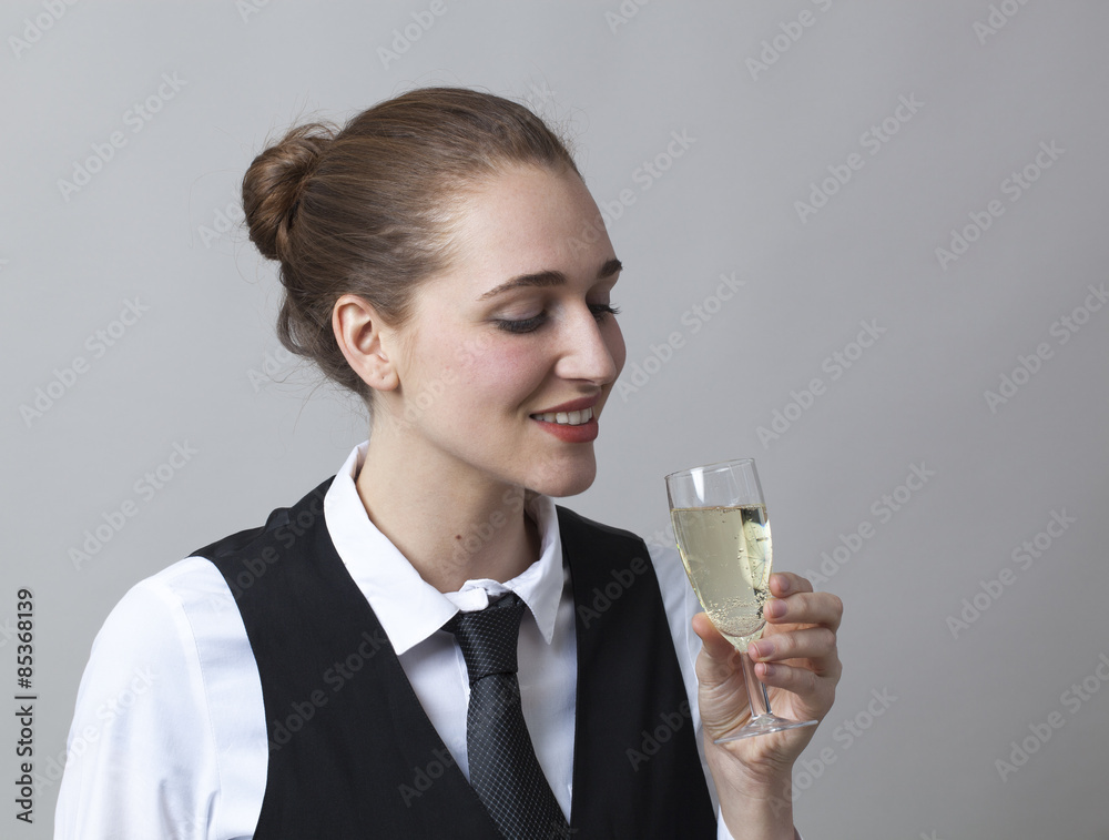 Beautiful young woman wearing uniform of wine waitress tasting a bubbly wine in glass of Champagne Beautiful young woman wearing uniform of wine waitress tasting a bubbly wine in glass of Champagne