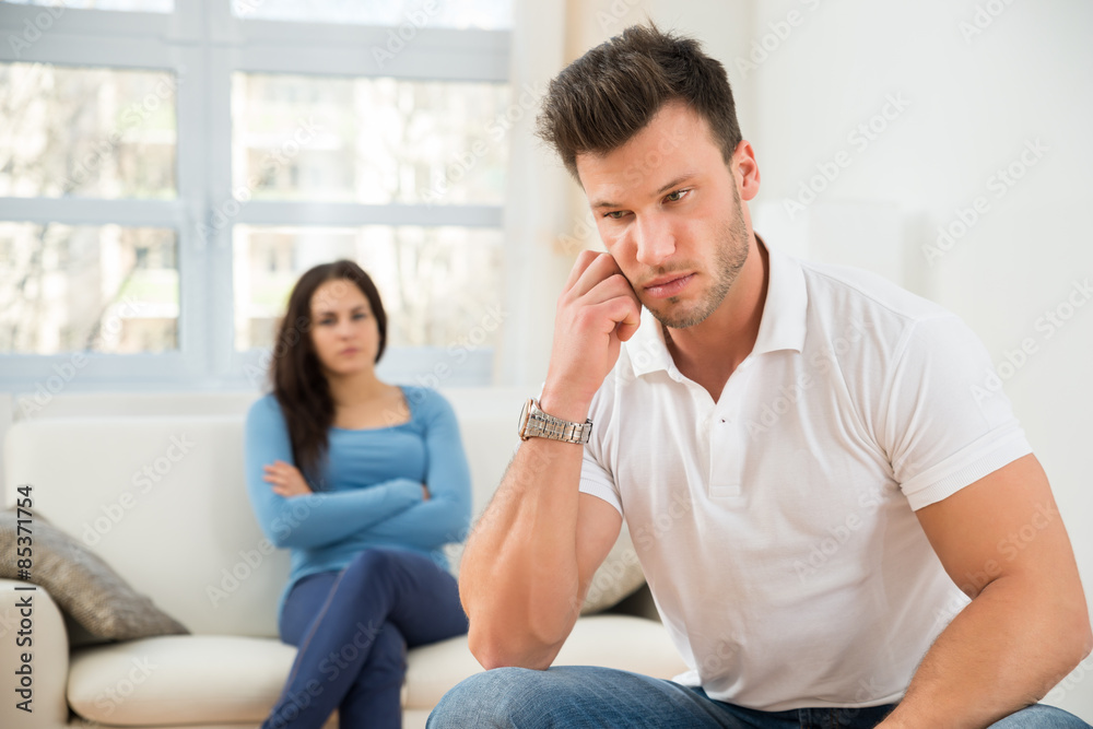 Defocused Woman In Front Of Sad Young Man Defocused Woman In Front Of Sad Young Man