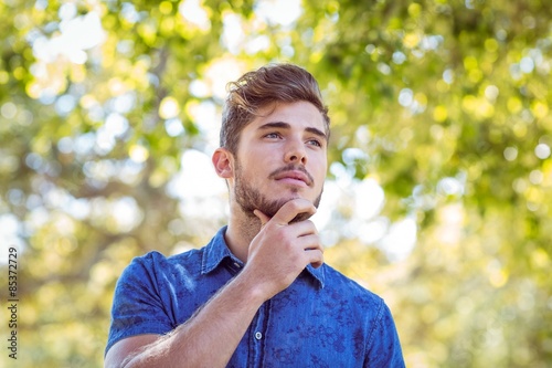 Foto Handsome thinking hipster in the park
