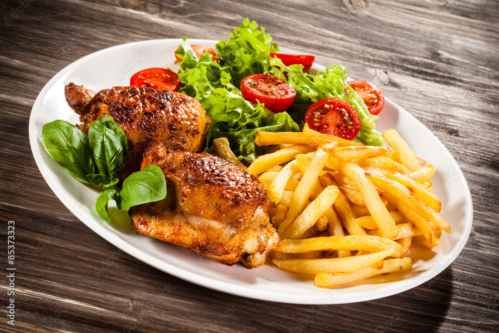 Grilled chicken legs with chips and vegetables Grilled chicken legs with chips and vegetables