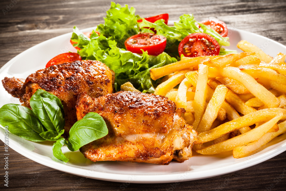 Grilled chicken legs with chips and vegetables Grilled chicken legs with chips and vegetables