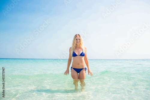 Smiling blonde woman walking into the ocean © WavebreakmediaMicro