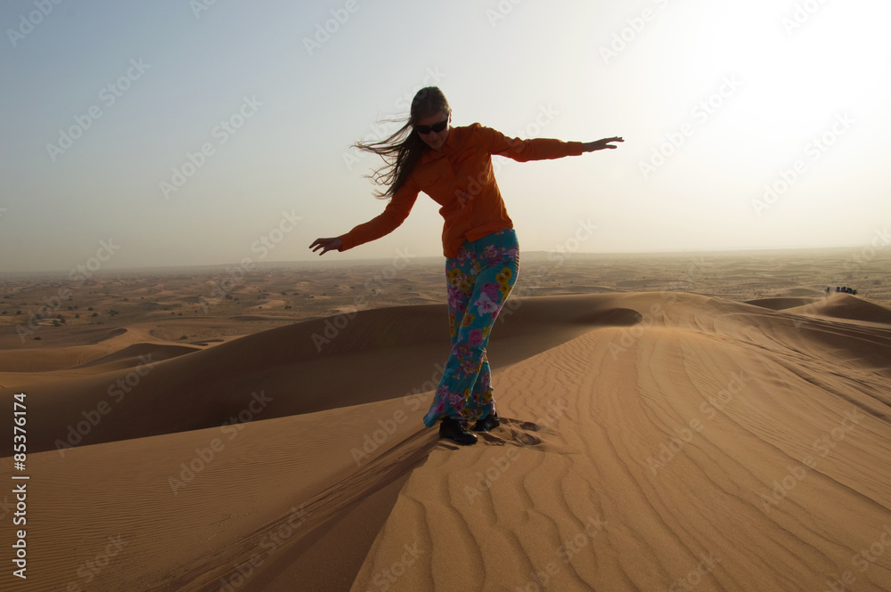 Young woman steps on sand dune in Rub 'al Khali, United Arab Emi