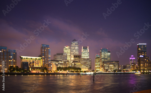 London, Canary Wharf in night with lights reflection in Thames water