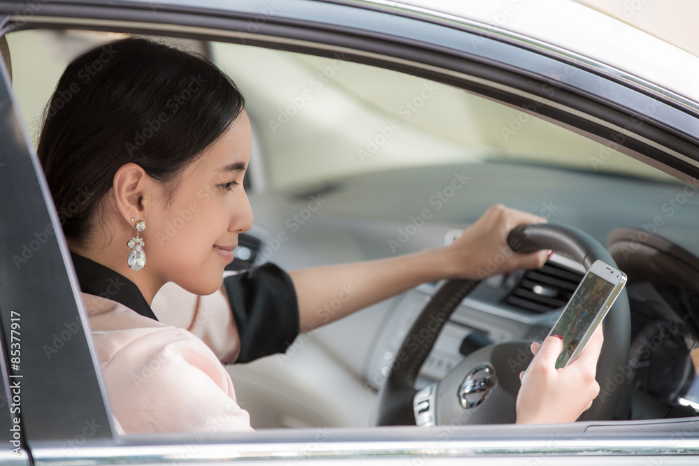 Beautiful young asian woman using map in mobile in a car