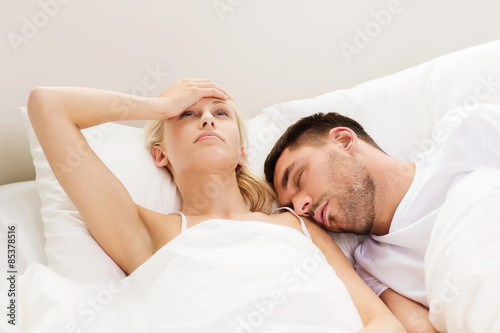 couple sleeping in bed at home