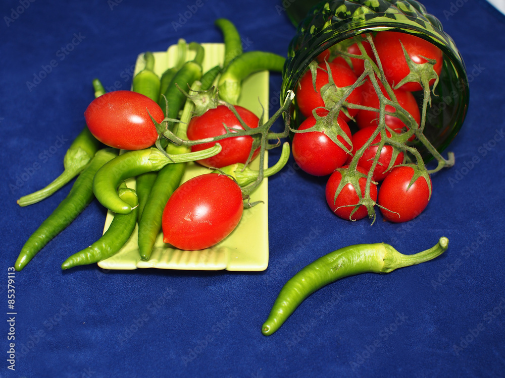 Red tomatoes and chili peppers on blue background Red tomatoes and chili peppers on blue background