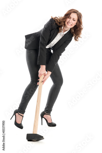 Geschäftsfrau versucht einen schweren Hammer zuheben