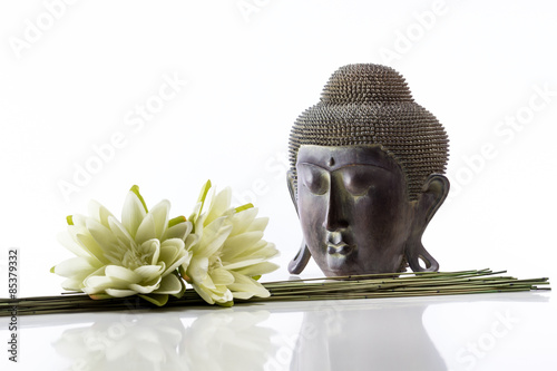 Cabeza de Buda sobre  un fondo blanco y flor de loto
