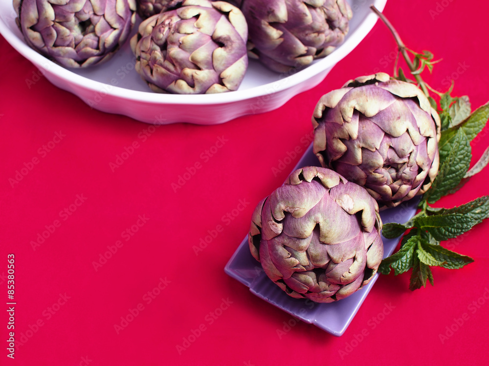 Obraz premium Purple artichokes on vivid background with copy space