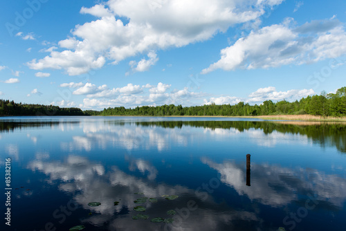 Fototapeta Naklejka Na Ścianę i Meble -  White clouds on the blue sky over blue lake