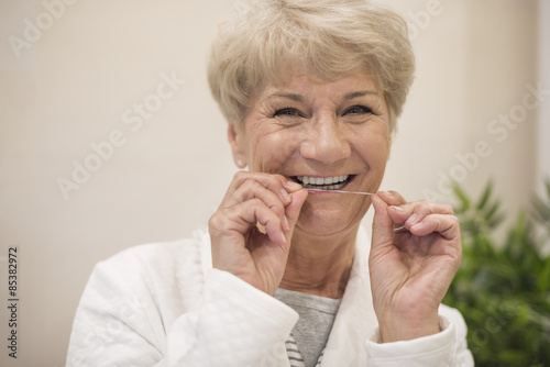 Cheerful woman cleaning her teeth