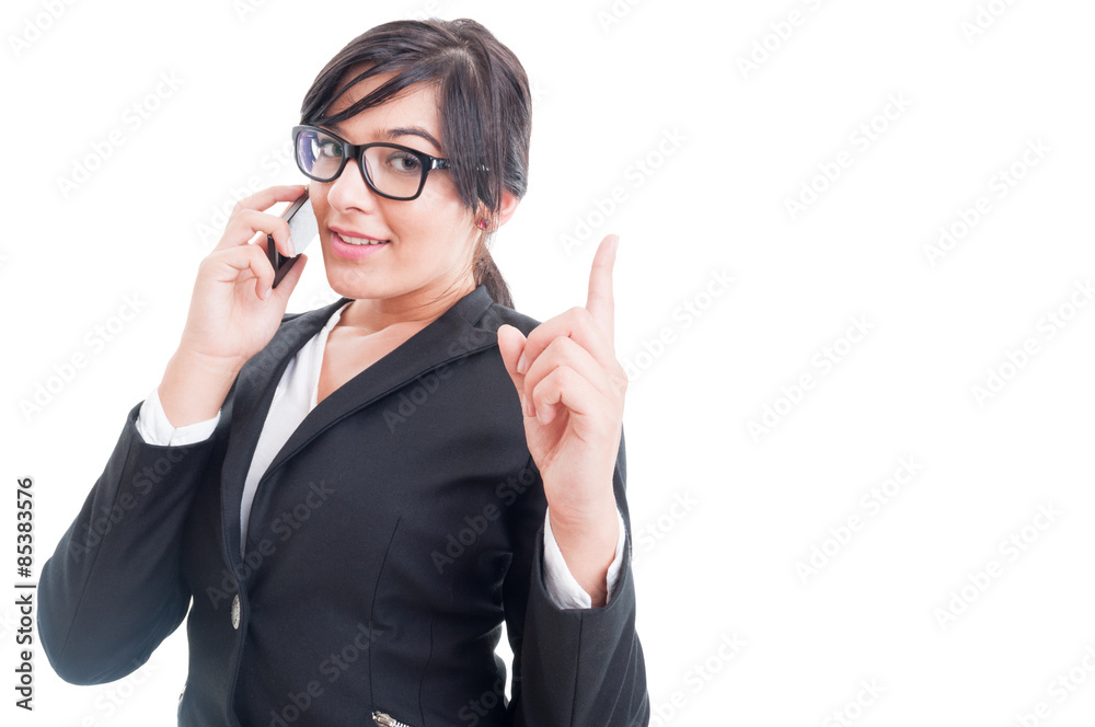 Saleswoman talking on the phone and making wait gesture Saleswoman talking on the phone and making wait gesture