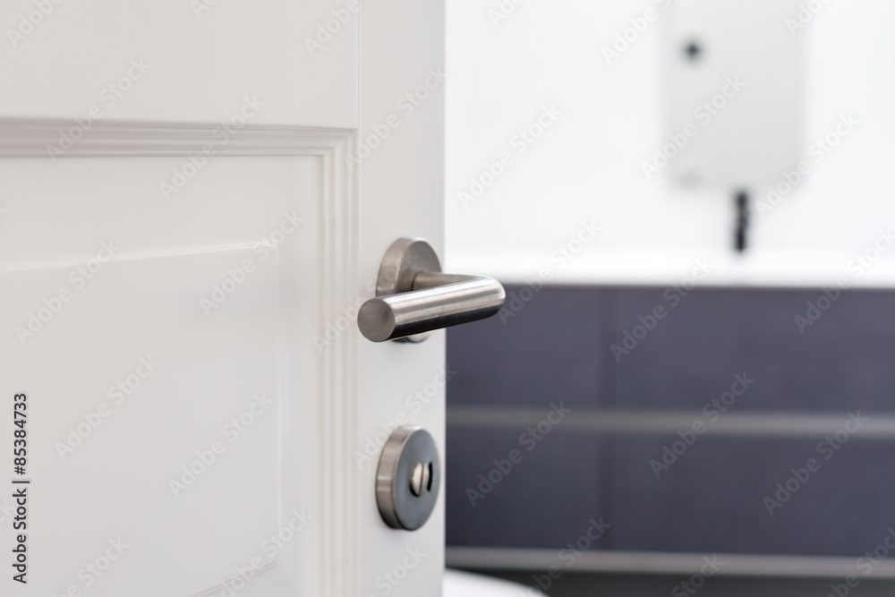 Fototapeta premium Open white door with metallic handle