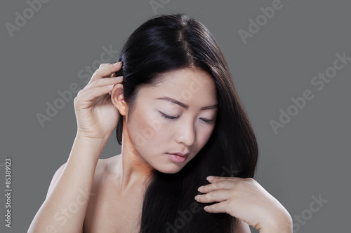 Woman with long hair on grey background