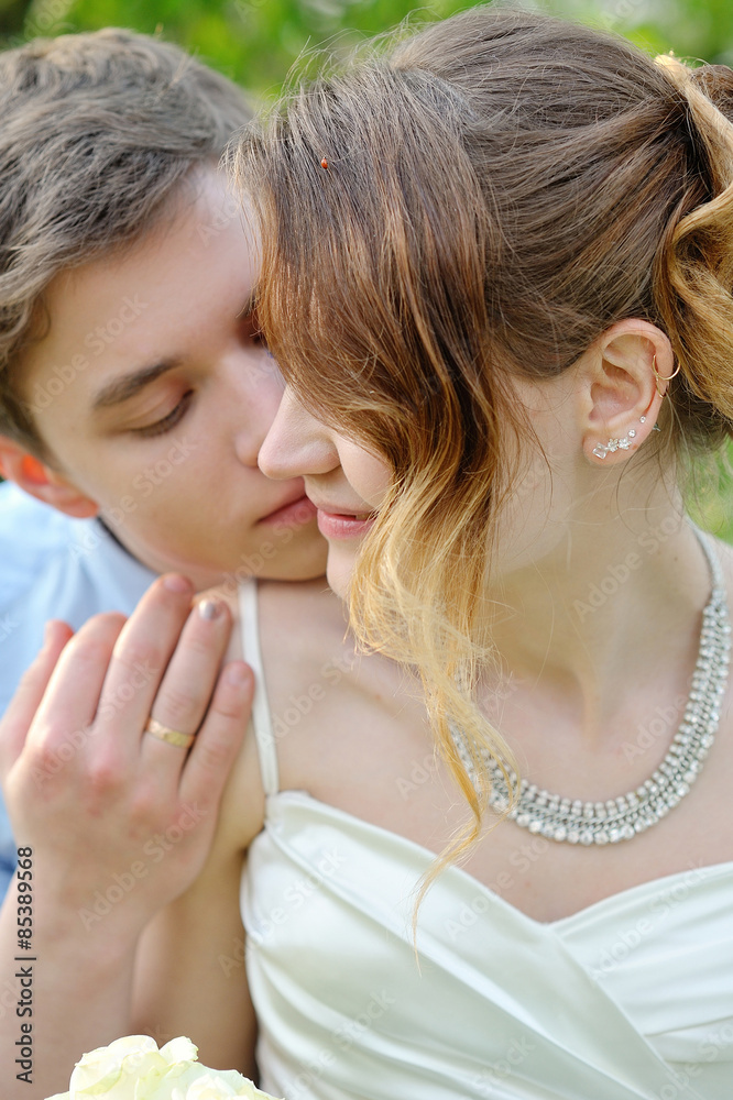 Fototapeta premium bride and groom kissing in the spring garden