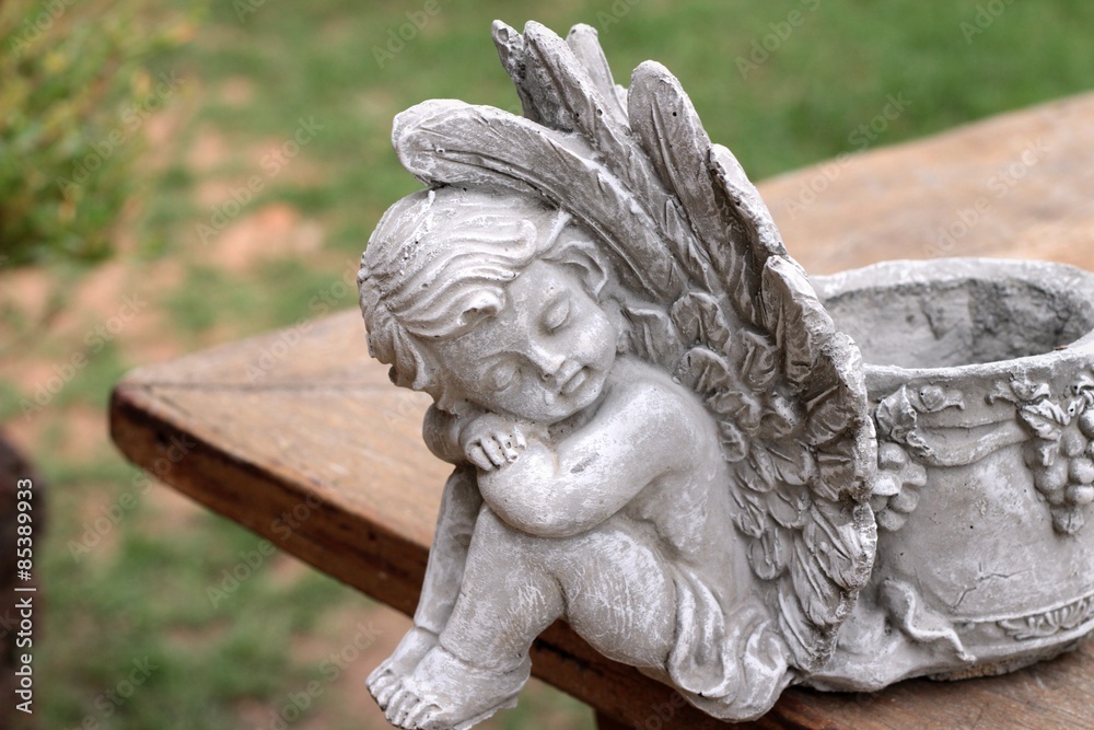 Vintage cupid sculpture on wood background