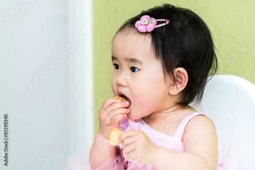Kleines asiatisches Mädchen beim essen photo
