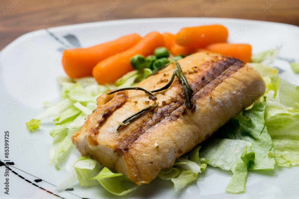 Salmon fillets served on a plate with mixed salad