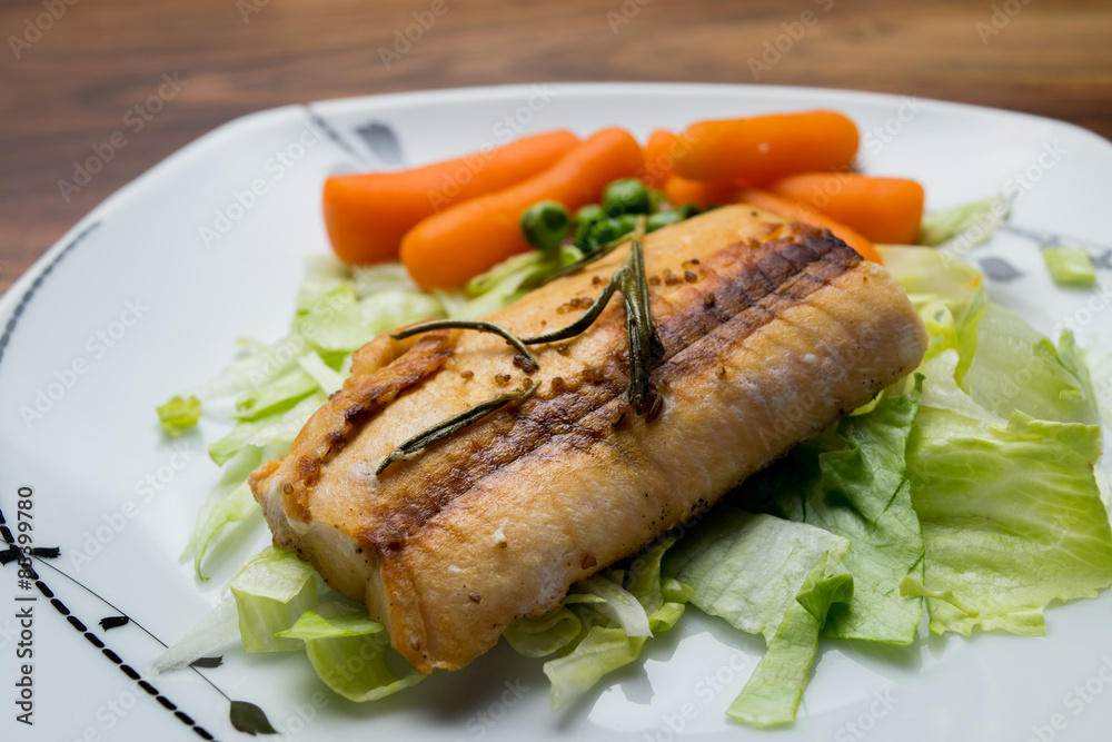 Salmon fillets served on a plate with mixed salad Salmon fillets served on a plate with mixed salad