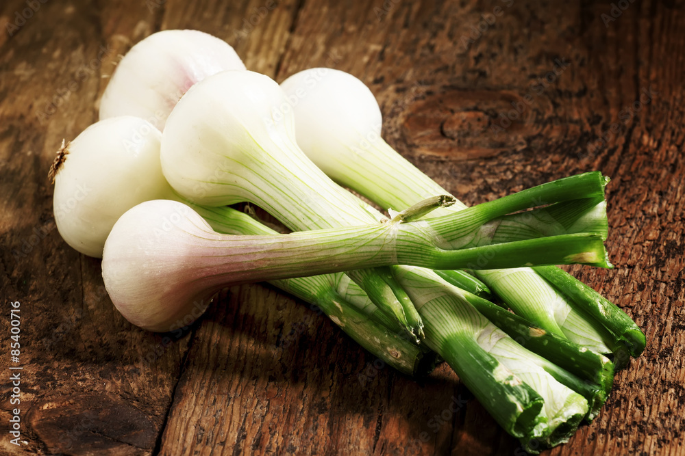 Fresh spring white onions with green stems, selective focus