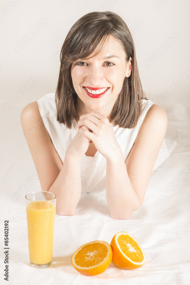 Happy woman with glass of fresh orange juice and orange slices, studio shot on white Happy woman with glass of fresh orange juice and orange slices, studio shot on white