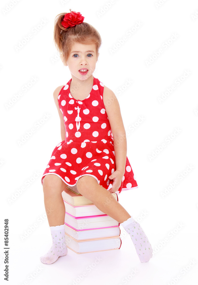 Beautiful Caucasian girl in a red dress with polka dots sitting Beautiful Caucasian girl in a red dress with polka dots sitting