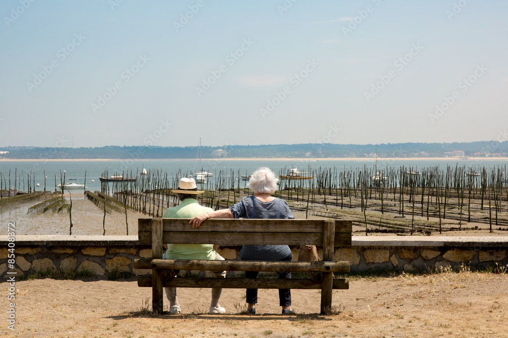 Couple sitting on the bench with their back to the camera Couple sitting on the bench with their back to the camera