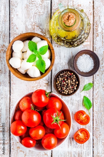 mozzarella, cherry tomatoes, salt, pepper, basil and olive oil for caprese salad