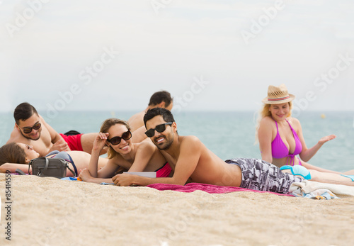  people laying on sand at beach