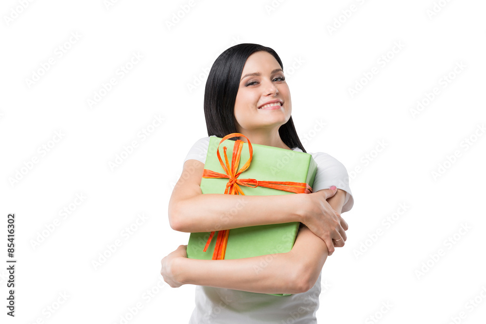 Happy brunette girl hugs the gift box. Isolated. Happy brunette girl hugs the gift box. Isolated.