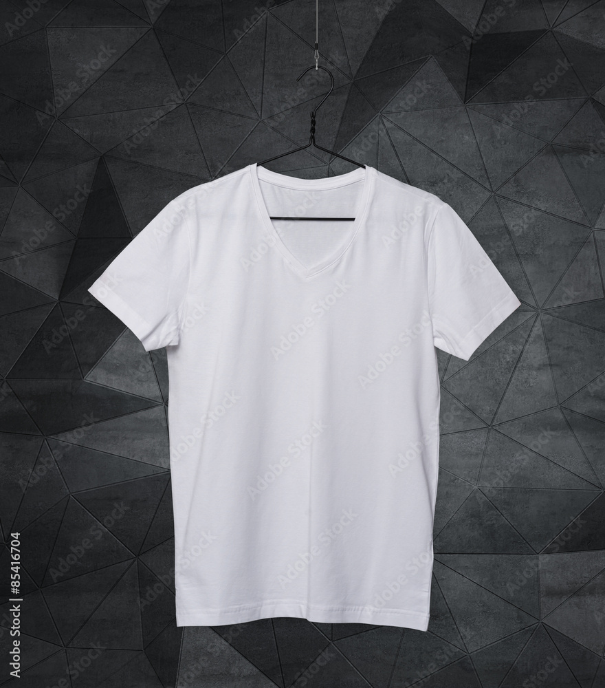 Close-up of the white t-shirt on the clothes hanger. Modern background. Close-up of the white t-shirt on the clothes hanger. Modern background.
