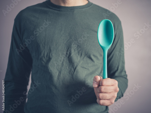 Young man holding a rubber spoon
