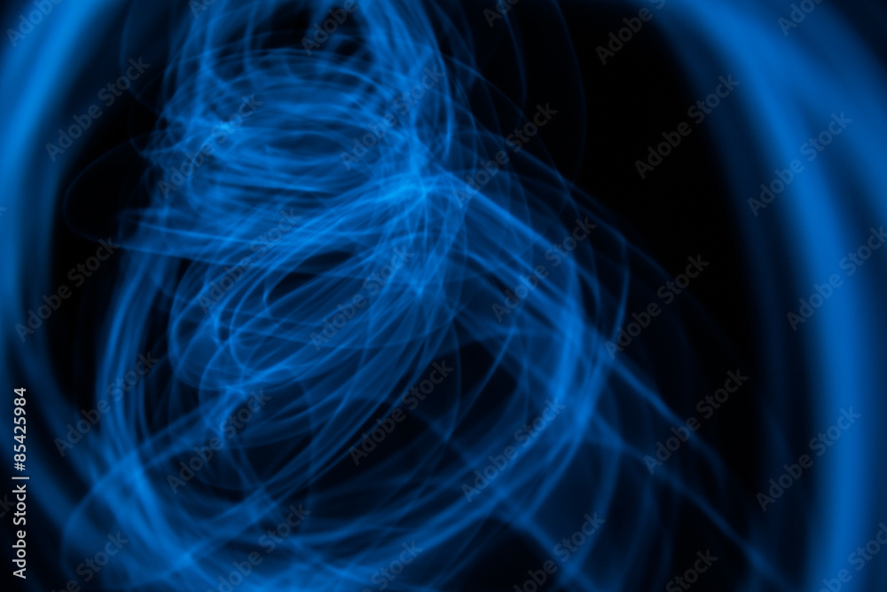 Glowing abstract curved lines.
Blue colors.
Black background.
Done by long exposure technique
