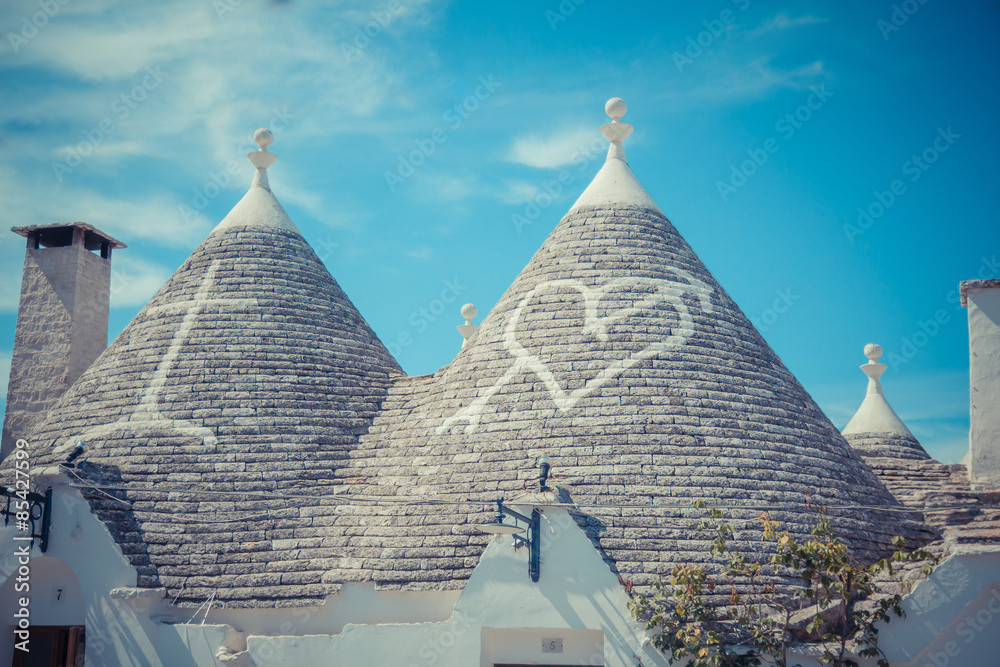 Close up of a conical roofs of a Trulli houses with painted symbols in the southern Italian town of Alberobello, Apulia, Italy
