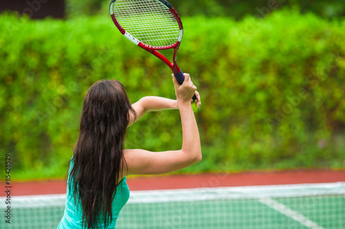 Young active woman playing tennis on tropical vacation