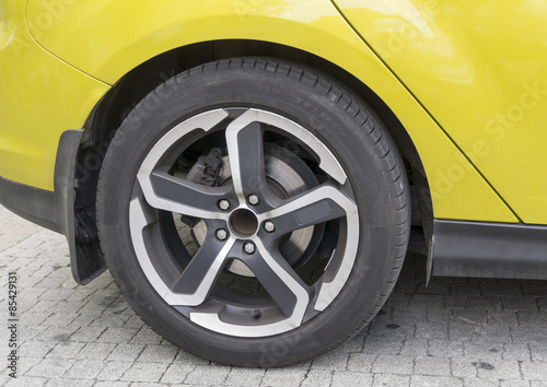 Yellow car closeup - rear wheel with light alloy rim