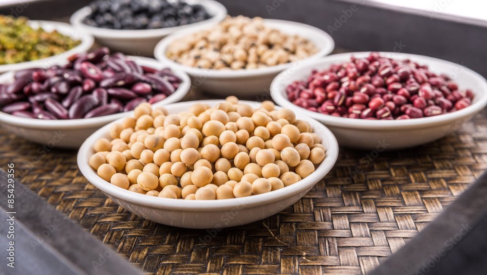 Beans variety in white bowl on in wicker tray