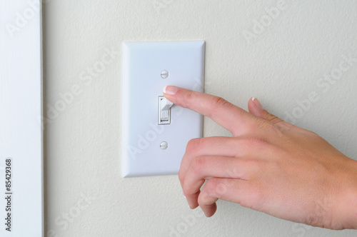 Woman turning off light switch