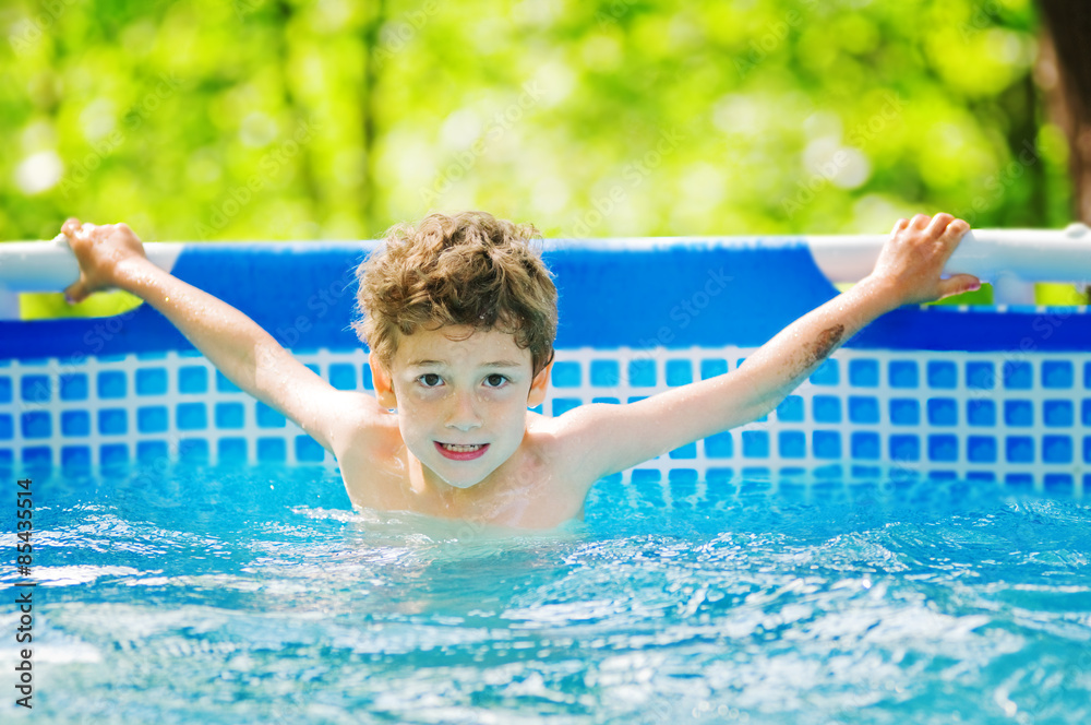 little boy swimming in an outdoor pool