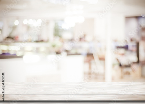Empty white table and blurred cafe with bokeh light background