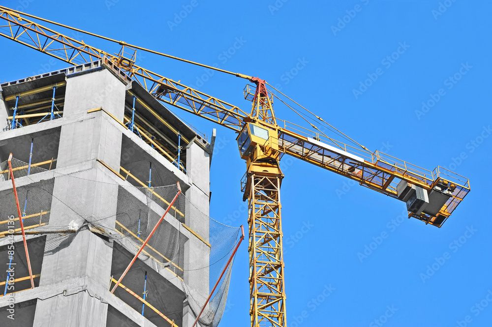 Crane and building construction site against blue sky