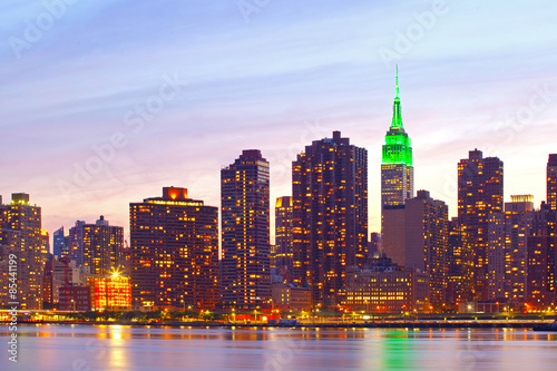New York City  Manhattan famous landmark buildings skyline in downtown at beautiful colorful sunset with reflections