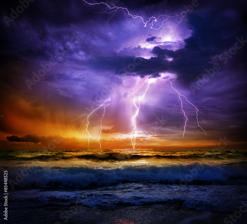Fotografiet lightning and storm on sea to the sunset - bad weather